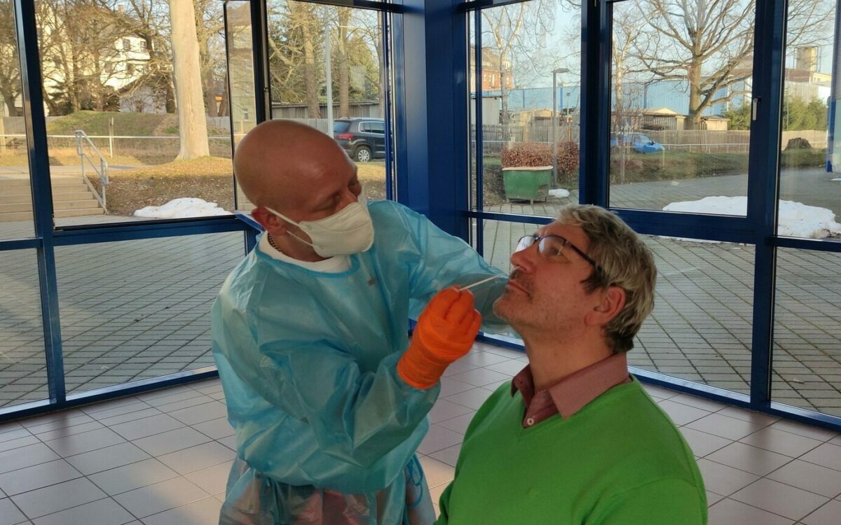 Ein medizinischer Angestellter nimmt Corona-Schnelltest bei einem Mann vor Ein medizinischer Angestellter nimmt Corona-Schnelltest bei einem Mann vor